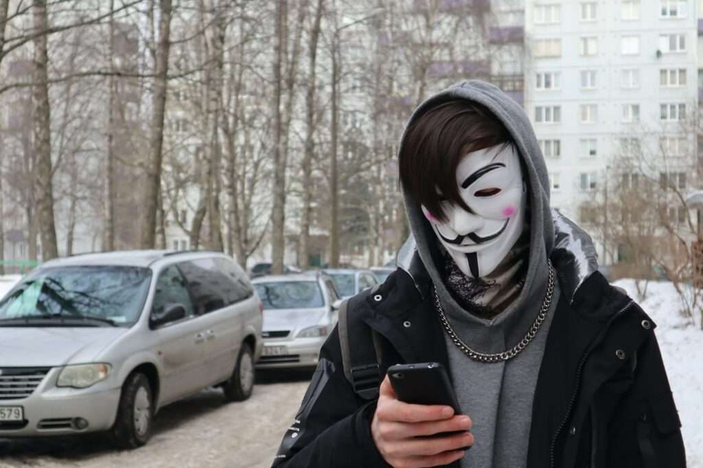 a person wearing a mask and holding a cell phone